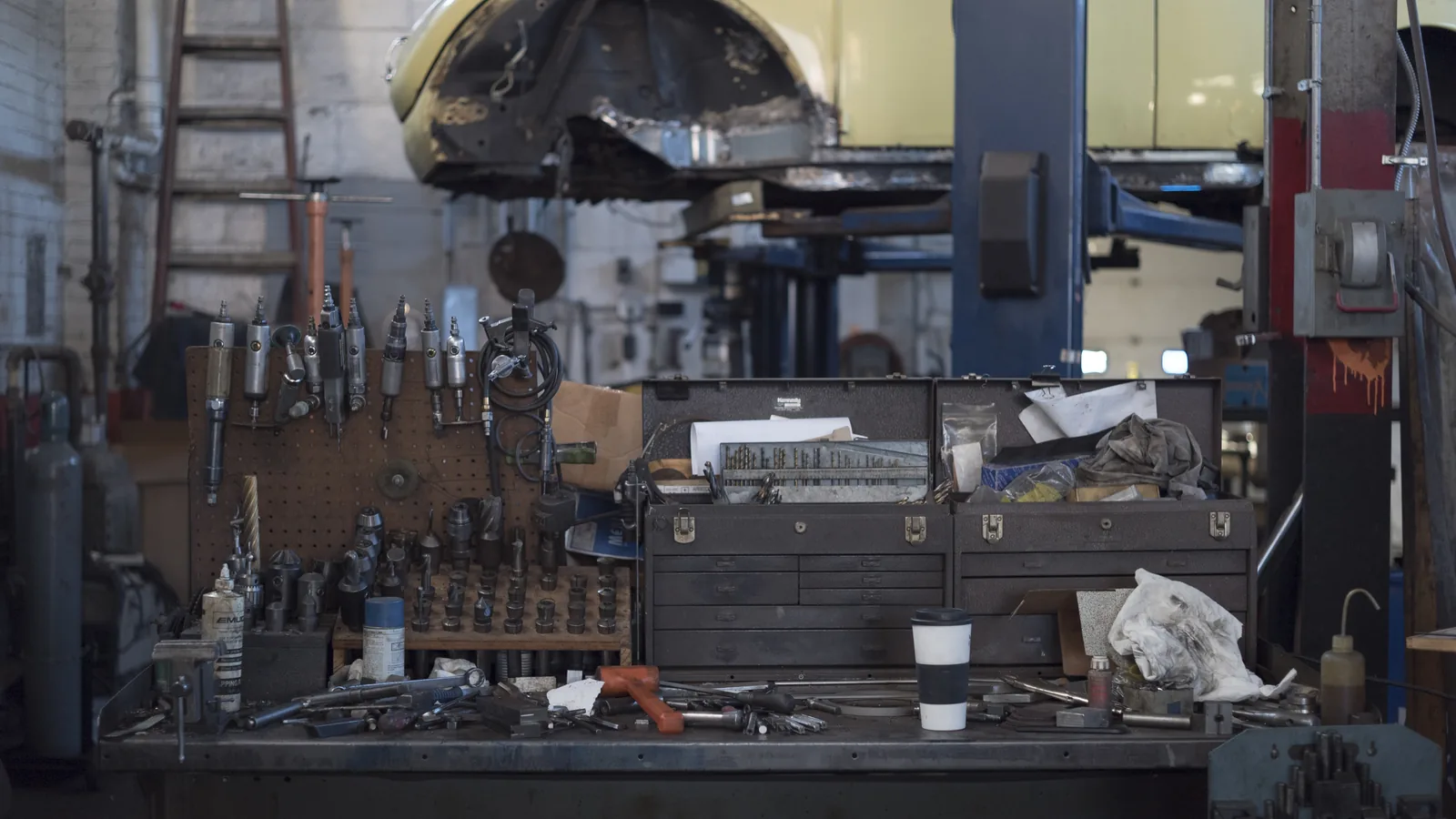 L'établi d'un atelier de mécanique, outils rangés sous une voiture sur pont